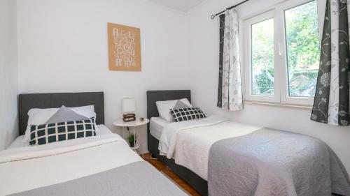 two beds in a room with a window at House Rilovic by Villas Guide in Srednji Radovčići
