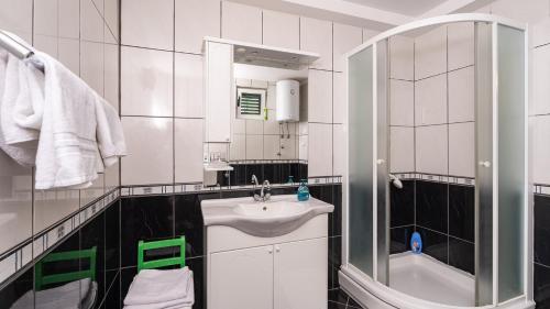 a white bathroom with a sink and a shower at Grand view Orasac by Villas Guide in Dubrovnik