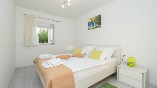 a white bed in a white room with a window at Cypress Paradise by Villas Guide in Dubravka
