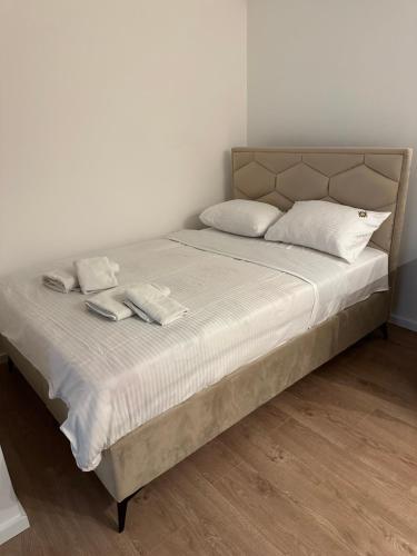 een bed met witte lakens en kussens erop bij Happy moments Studio Kraljevo in Kraljevo