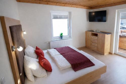 een slaapkamer met een bed met rode kussens bij Haus am Lift in Kleinarl