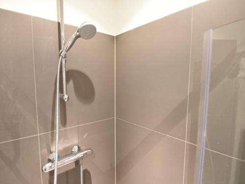 een douche met een douchekop in een badkamer bij Alluring Apartment in Bergen with Terrace, Garden and BBQ in Bergen