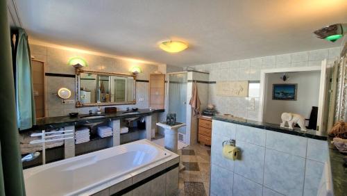 a large bathroom with a tub and a sink at Alpine Schmiede Chalet in Ehrwald