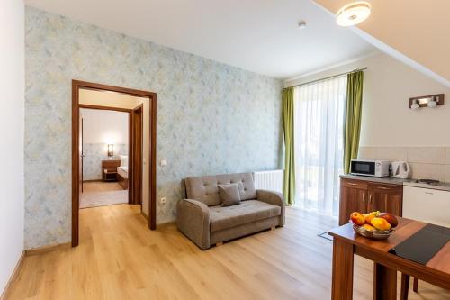 a living room with a couch and a table and a kitchen at B&B Lajta Park in Mosonmagyaróvár