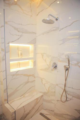 a bathroom with a marble shower with a glass door at المحافظة in Kafr al Ishārah