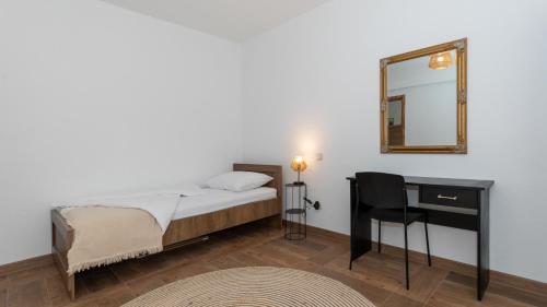 una camera con letto, specchio e scrivania di Villa Dolina Opuzen by Villas Guide a Podgradina