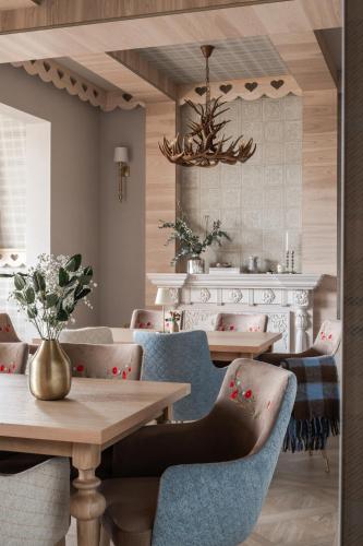 a dining room with tables and chairs and a chandelier at Willa Jędruś in Murzasichle