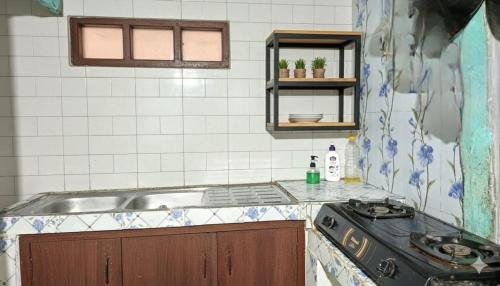 een keuken met een spoelbak en een fornuis bij Bram Komodo Homestay in Komodo