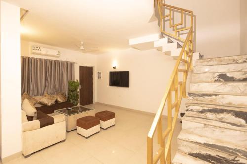 ein Wohnzimmer mit Treppe und Couch in der Unterkunft Nandan Retreat 4-Star Hotel & Luxury Villas Near Prem Mandir, Vrindavan in Vrindāvan