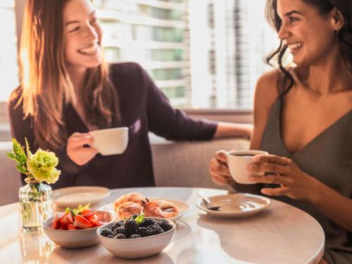 two women sitting at a table with a plate of food at Fairmont Chicago Millennium Park in Chicago