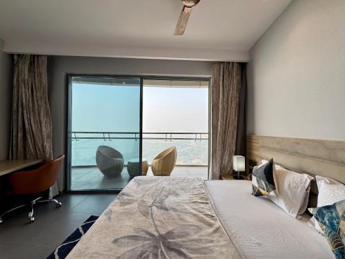a bedroom with a bed and a large window at Mulberry Homes Supernova in Noida