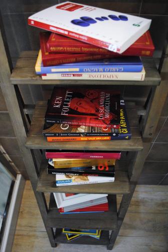 a stack of books on a wooden book shelf at Festina Lente B&B in Porto Recanati