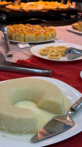 un piatto bianco con un pezzo di torta su un tavolo di Hotel Áster ad Alagoinhas
