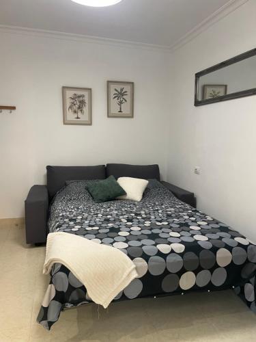 a bedroom with a black and white comforter on a bed at casa kayla in Palm-Mar