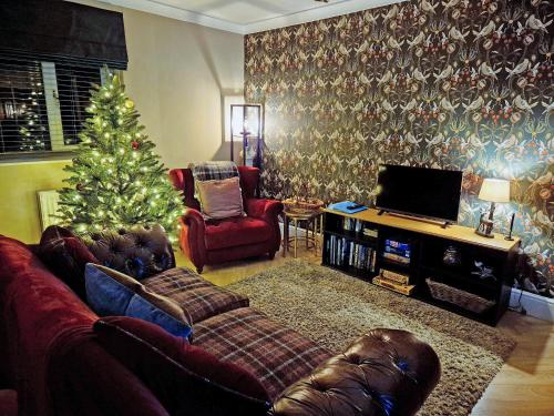 ein Wohnzimmer mit einem Weihnachtsbaum und einer Couch in der Unterkunft Silent Springs in Nawton