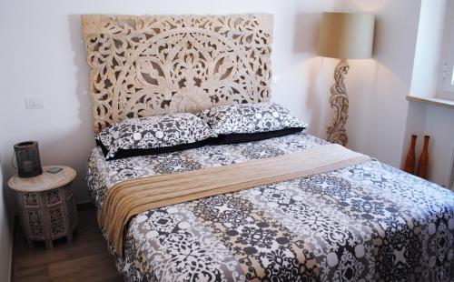 a bedroom with a bed with a headboard and pillows at Festina Lente B&B in Porto Recanati
