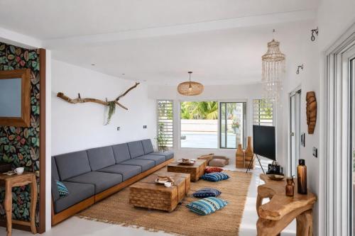 a living room with a couch and a table at Tia Beach House - Beachfront Villa, Pool & Hammam in Albion