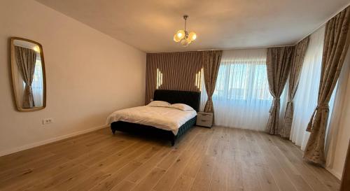 a bedroom with a bed and a large window at Casa Romanța in Cehu Silvaniei