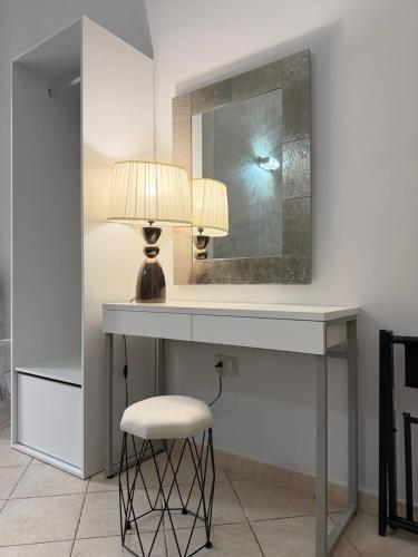 a dressing table with a lamp and a mirror at Dimora Lanamar in Conversano