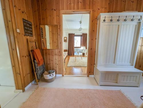 a room with wooden walls and a hallway with a door at A little home in Lahti