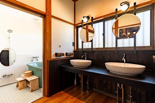 een badkamer met 2 wastafels en een bad bij 陽和リトリート in Tateyama