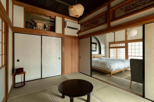 een slaapkamer met een bed en een tafel bij 陽和リトリート in Tateyama