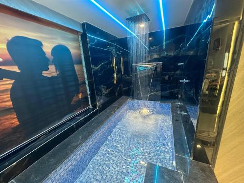 a bathroom with a plunge pool with a shadow of a couple at Hotel THE Vibes in Koba