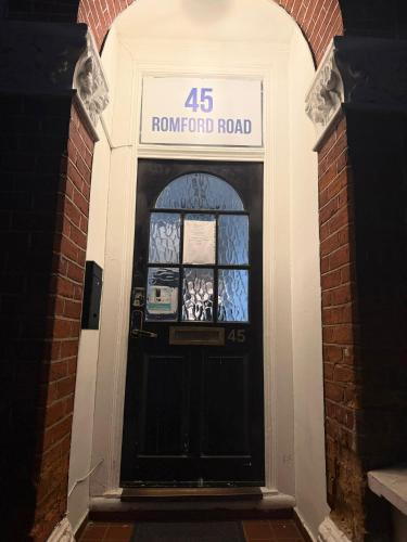 a black front door of a renovated road at Rayan's Lodge Stratford London by OYO in London