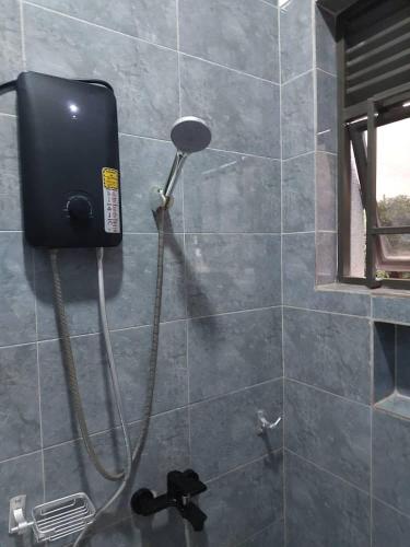 a shower with a blow dryer in a bathroom at Mwisenix apartment in Kigali