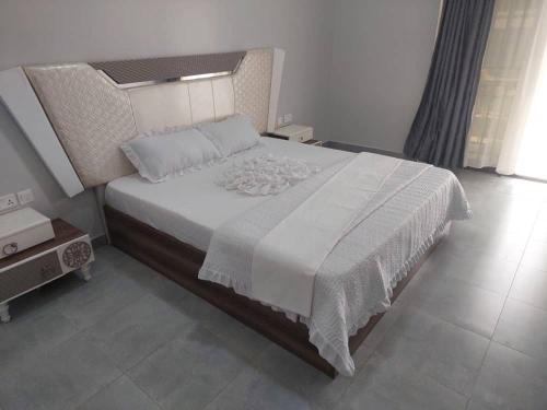 a bedroom with a large bed with a white comforter at Mwisenix apartment in Kigali