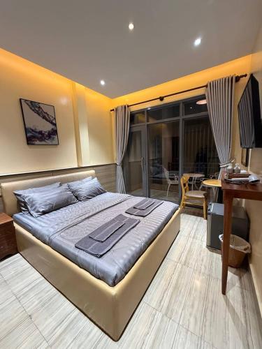 a bedroom with a bed and a desk with a computer at The Ray Hotel & Apartments in Phnom Penh