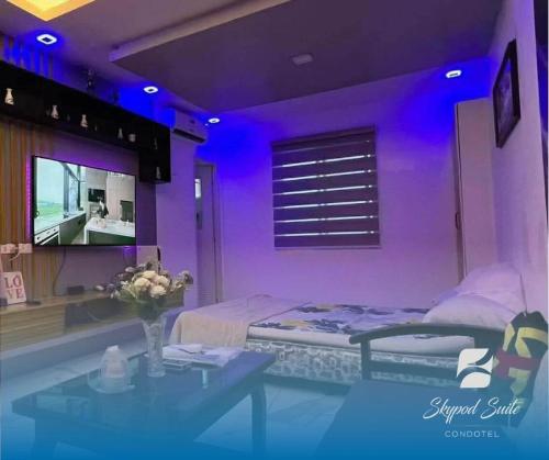 een paarse kamer met een bed en een tafel bij RXS SkyPod #3 Suite Condotel - Roxas City in Roxas City