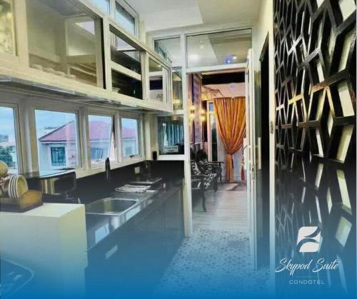 een grote woonkamer met blauwe vloeren en ramen bij RXS SkyPod #3 Suite Condotel - Roxas City in Roxas City