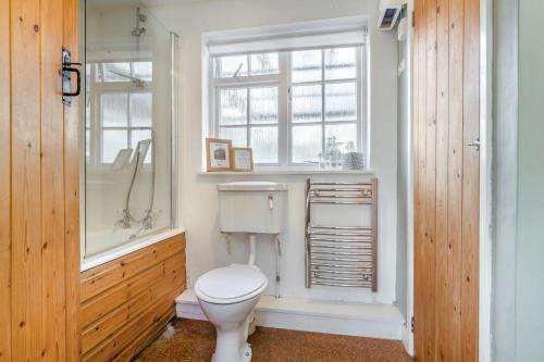 a bathroom with a toilet and a shower and a window at 3 Bed in Awre oc-s34503 in Awre