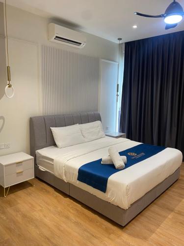 a bedroom with a large bed with a blue blanket at Quill Residence Suites KLCC By Sara in Kuala Lumpur