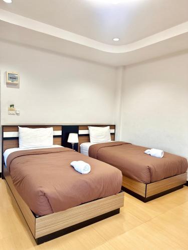 two beds sitting next to each other in a room at Smile Place (สมายเพลส) in Chom Thong