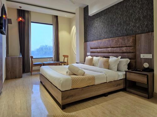 a bedroom with a large bed with a wooden headboard at Hotel The SOHO in Chandīgarh