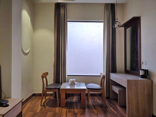een kamer met een tafel, stoelen en een raam bij Hotel The SOHO in Chandīgarh