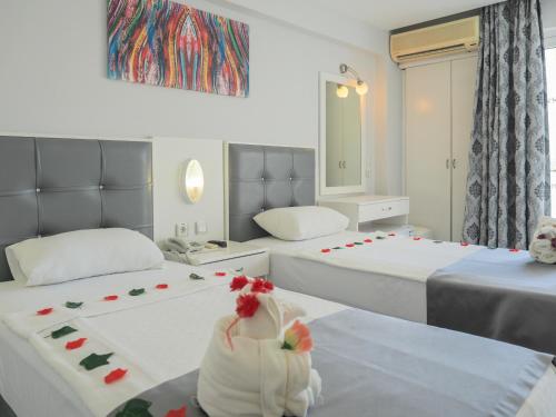 - une chambre d'hôtel avec 2 lits fleuris dans l'établissement Halıcı Hotel Marmaris, à Marmaris