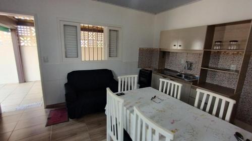 een keuken en eetkamer met een tafel en een stoel bij Casa quadra mar in Arroio do Silva