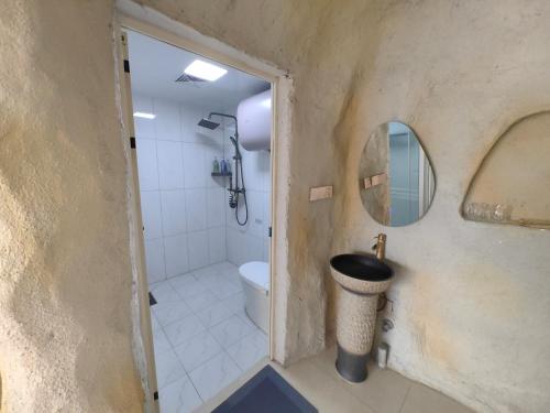a bathroom with a toilet and a sink and a mirror at Xinchen B&B in Ge Dao