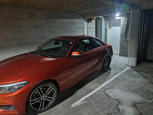 un'auto rossa parcheggiata in un parcheggio di La suite d'Isa a Lens