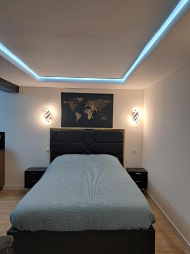 a bedroom with a bed with two lights on the wall at La suite d'Isa in Lens