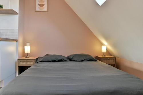 un letto con due cuscini in una camera con due lampade di Les Trois Rois 6 - Centre Avranches ad Avranches