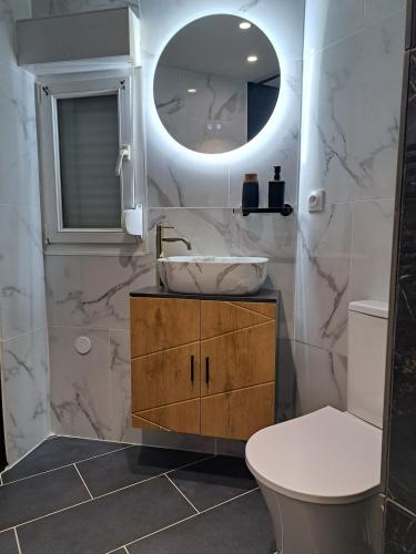 a bathroom with a sink and a toilet and a mirror at La suite d'Isa in Lens