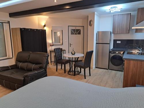 una cucina e un soggiorno con un divano e un tavolo di La suite d'Isa a Lens