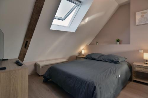ein Schlafzimmer mit einem Bett und einem Dachfenster in der Unterkunft Les Trois Rois 5 - Centre Avranches in Avranches