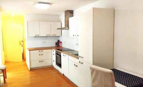 una cucina con mobili bianchi e un forno a piano cottura di Bahnhofstrasse a Klagenfurt