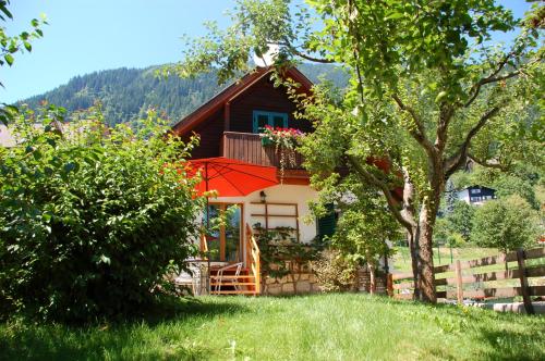 a house with a balcony and a tree at Villa Marienhof in Annenheim