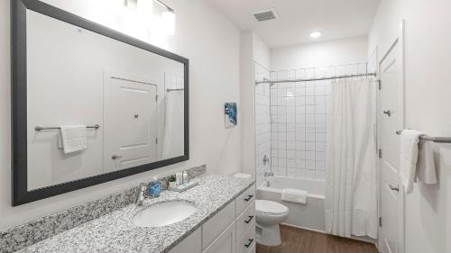 een badkamer met een wastafel, een toilet en een spiegel bij Landing Beautiful 3BD Yoga Studio Pool in Athens